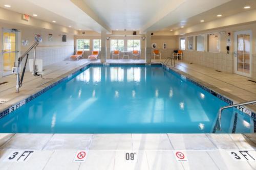 une grande piscine intérieure d'eau bleue dans un bâtiment dans l'établissement Candlewood Suites Windsor Locks, an IHG Hotel, à Windsor Locks