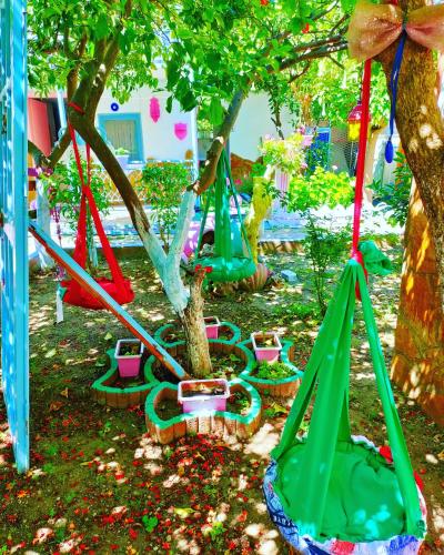 a group of swing sets under trees in a yard at Side Erenler Hotel in Side