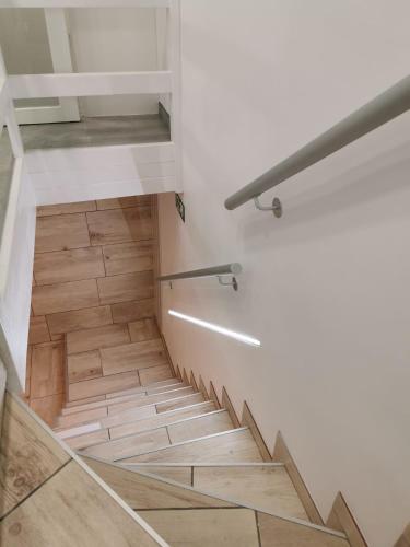 a staircase with a wooden floor and white walls at Vakantiehuis H&A 4 sterren in Ypres