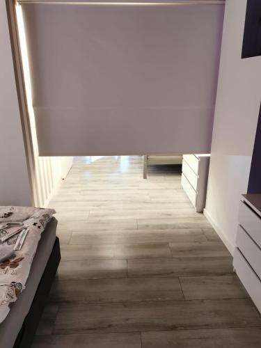 a room with a bed and a wooden floor at Vakantiehuis H&A 4 sterren in Ypres