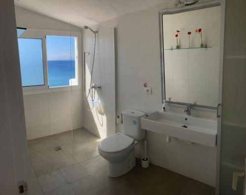 a bathroom with a toilet and a sink and a window at Casa Tito in Puerto del Carmen