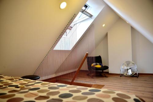 an attic room with a staircase and a bed at Jono Apartment in Klaipėda