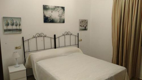 1 dormitorio con 1 cama con colcha blanca en Alojamiento rural " Las Carmenes ", en Algar