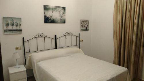 une chambre avec un lit avec un couvre-lit blanc dans l'établissement Alojamiento rural " Las Carmenes ", à Algar