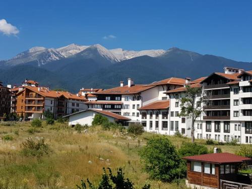 a group of buildings with mountains in the background at Edelweiss Inn Aparthotel, Apartment 32 in Bansko