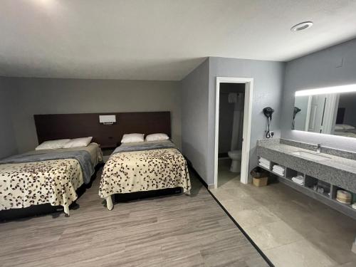 a bedroom with a bed and a bathroom with a sink at Ridge Motel in Breckenridge