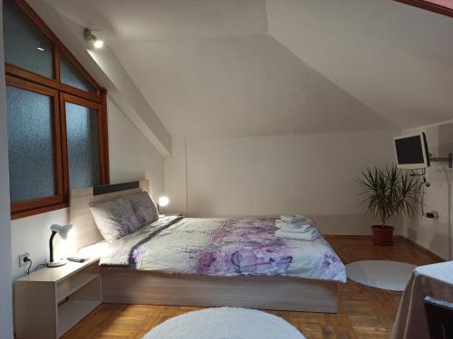 a bedroom with a bed with a purple comforter at Guest House Ganovi in Kalofer