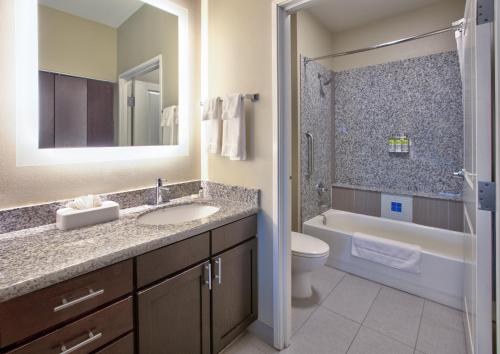 a bathroom with a sink and a tub and a toilet at Staybridge Suites Plano - Richardson Area by IHG in Plano
