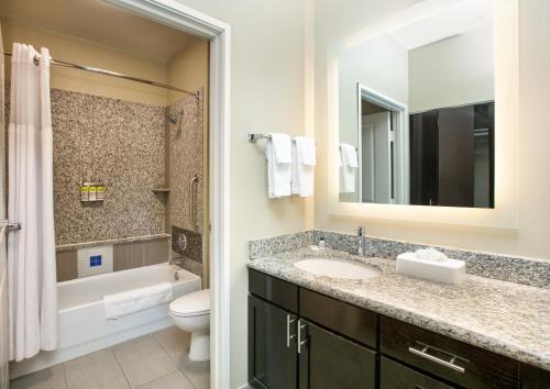 a bathroom with a sink and a toilet and a mirror at Staybridge Suites Plano - Richardson Area by IHG in Plano
