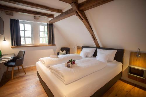 a bedroom with a large white bed with a desk at Altstadthotel Treysa in Schwalmstadt