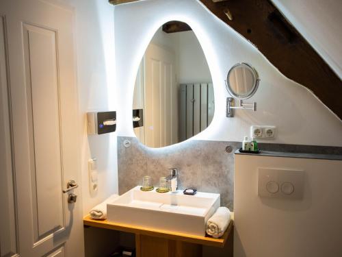 ein Bad mit einem Waschbecken und einem Spiegel in der Unterkunft Altstadthotel Treysa in Schwalmstadt