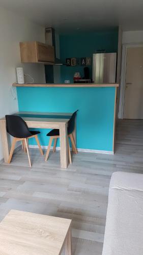 una mesa azul y una silla en una habitación en appartement entre Mer et Corbières, en Cuxac-dʼAude