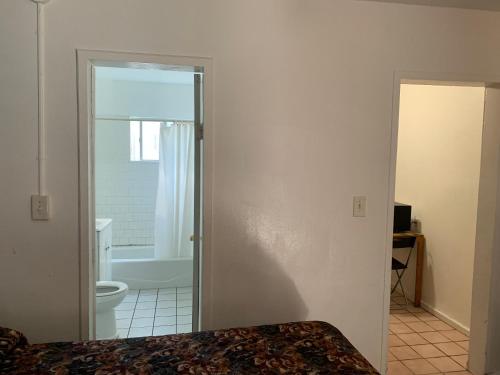 a bathroom with a shower and a toilet and a door at Encore Inn in Inglewood