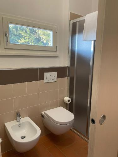 a bathroom with a toilet and a sink and a window at Dimora Toscana in Treggiaia