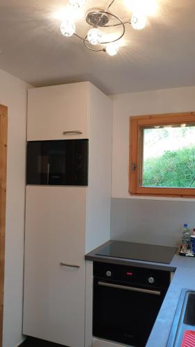 une cuisine avec un réfrigérateur blanc et une fenêtre dans l'établissement Le Grossglockner, aux Contamines-Montjoie