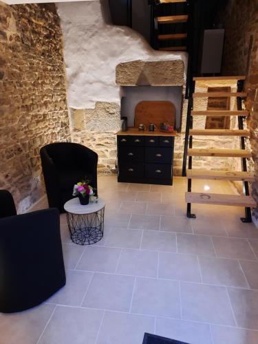 a living room with a staircase and a stone wall at Mill D'Arx in Château