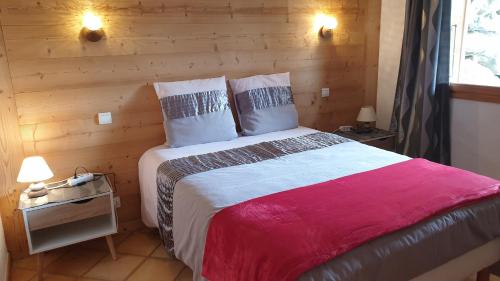 1 dormitorio con 1 cama grande y pared de madera en Le Grossglockner en Les Contamines-Montjoie