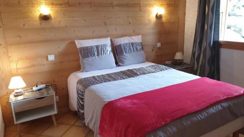 une chambre avec un grand lit avec un mur en bois dans l'établissement Le Grossglockner, aux Contamines-Montjoie