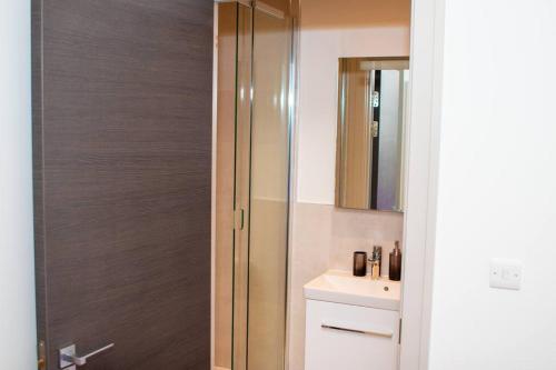 a bathroom with a sink and a glass shower at Stunning 1-Bedroom flat in London! in London