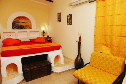 a bedroom with a bed with a fireplace and a chair at Mantas Bay in Vouliagmeni Lake