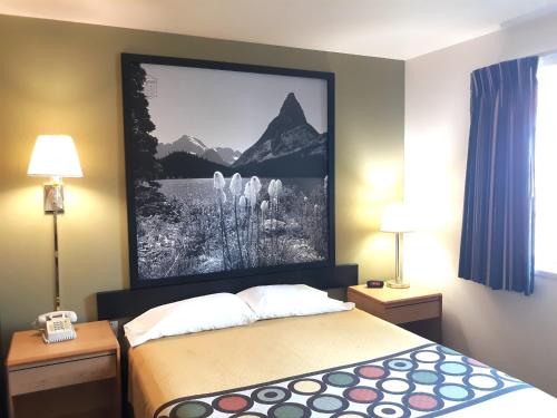 une chambre d'hôtel avec un lit avec une photo sur le mur dans l'établissement Super 8 by Wyndham Hamilton, à Hamilton