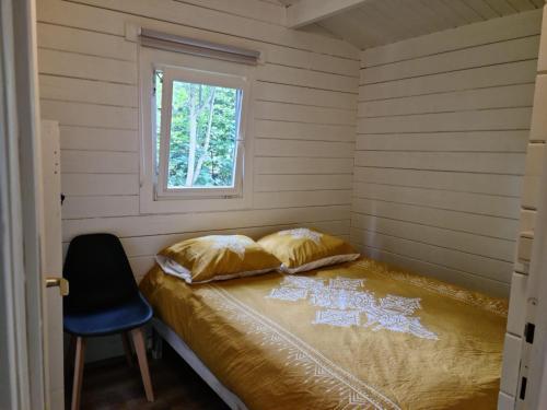 a small bedroom with a bed with a window at Casa Ibiza is vakantie in Drenthe in Schoonebeek