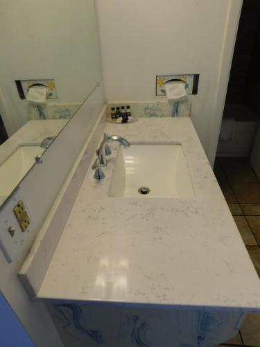a white sink in a bathroom with two toilets at Drifter Motel in Silver City