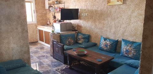 a living room with a blue couch and a table at Brothers House 2 in Imsouane