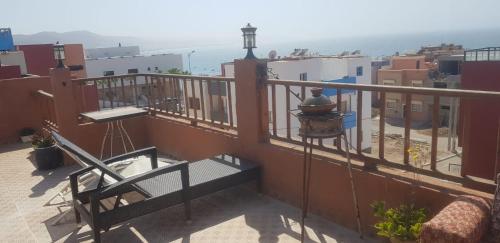 a balcony with a bench and a view of the ocean at Brothers House 2 in Imsouane