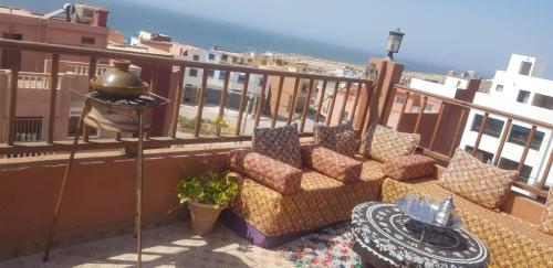 a balcony with chairs and a table and the ocean at Brothers House 2 in Imsouane