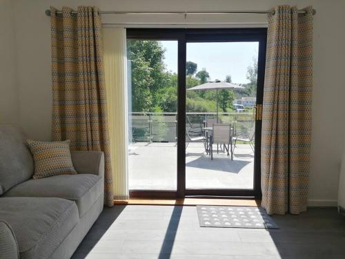 a living room with a couch and a sliding glass door at Cottage by the river in Cenarth with seasonal fishing and Wifi in Cenarth