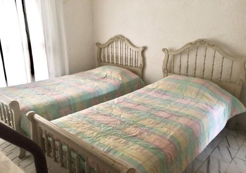 een slaapkamer met 2 aparte bedden en een raam bij Casa Victoria by Dicasi Vacations in Texcalpan