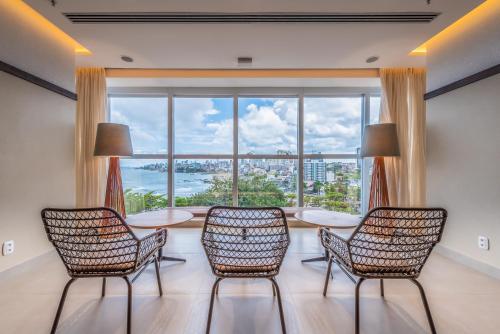 a room with a table and chairs and a large window at Novotel Salvador Rio Vermelho in Salvador