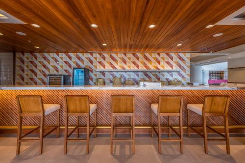 a row of chairs in front of a bar at Novotel Salvador Rio Vermelho in Salvador