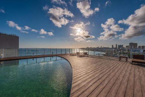 a wooden deck with a pool of water on a building at Novotel Salvador Rio Vermelho in Salvador