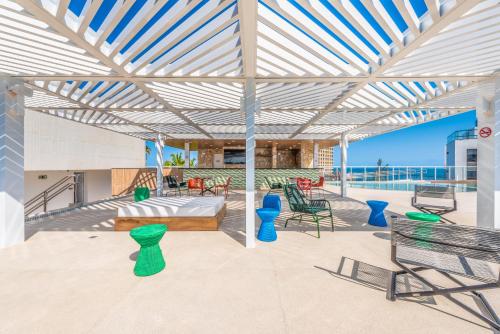 a patio with a bed and tables and chairs at Novotel Salvador Rio Vermelho in Salvador