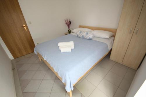a small bedroom with a bed with towels on it at Apartments Gina in Trogir