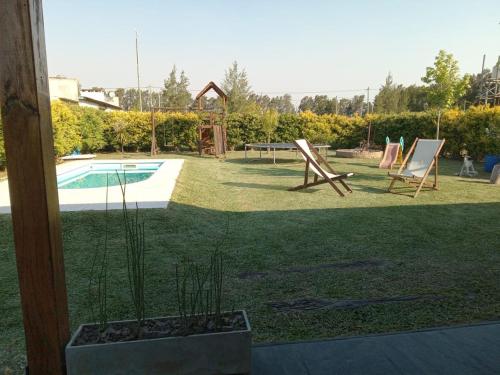 a yard with a pool and chairs and a table at Casa Quinta Abuelo Gordo in San Pedro
