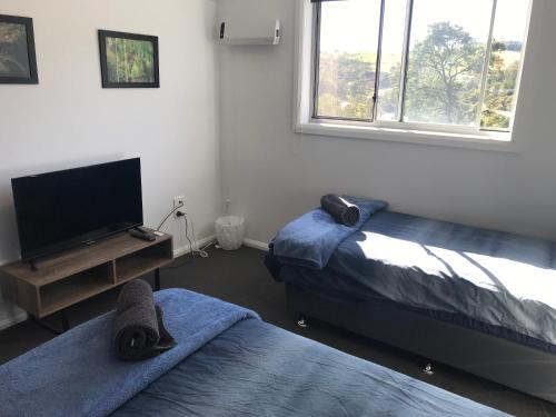a bedroom with two beds and a flat screen tv at Derby Digs Barn in Derby