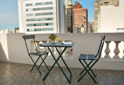 two chairs and a table on a balcony at Hotel Palacio in Montevideo