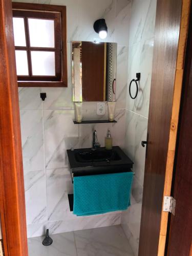 a bathroom with a sink and a mirror at Casa bem espaçosa com piscina, campo de futebol e área gourmet a um quarteirão da lagoa de Praia Seca in Araruama