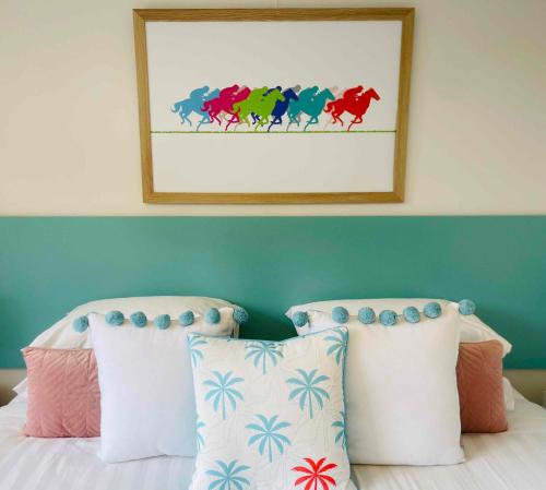 a bedroom with a bed with a picture of horses on the wall at Botanic Racecourse Apartments in Warrnambool