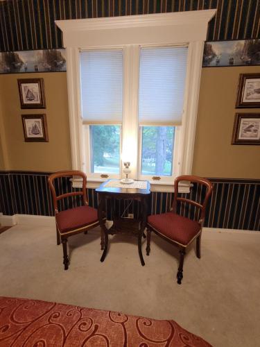 a dining room with a table and two chairs and a window at Ruby Manor Bed & Breakfast in Gananoque