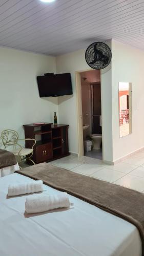 a hotel room with a bed and a tv on the wall at Pousada Casa Doce Vida in Águas de Lindóia