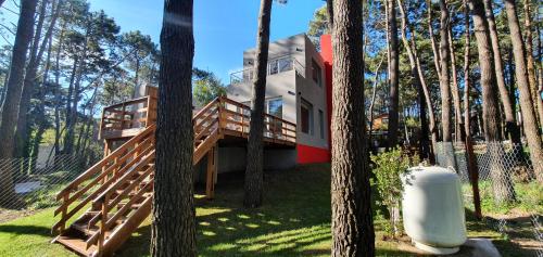una casa en medio de un bosque con árboles en EL PINAR CASA DE PLAYA en Balneario Mar Azul