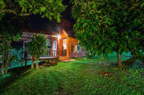 a house with a lit up yard at night at บ้านสวนศรเพชร in Phetchabun
