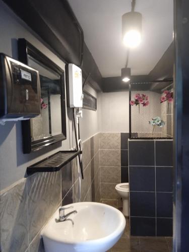 a bathroom with a sink and a toilet at บ้านศรีมีทรัพย์ เขาค้อ in Khao Kho