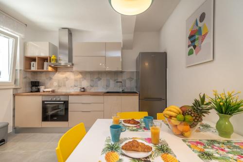 a kitchen with a table with fruit on it at House POLUS in Trogir