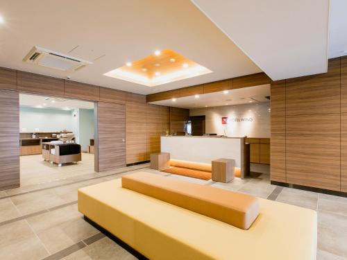 uma sala de estar com um sofá no meio em Hotel Wing International Takamatsu em Takamatsu