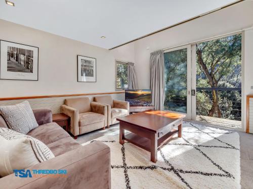 a living room with a couch and a table at Ramshead Creek 1 in Thredbo